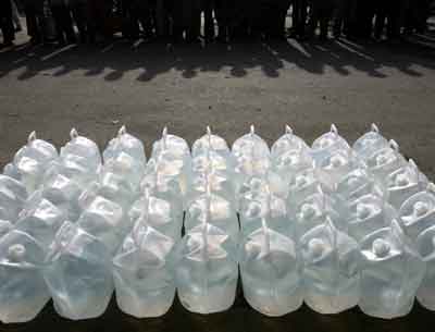 Acehnese wait in a line for drinking water provided by the Australian military in the tsunami-hit city of Banda Aceh, on the Indonesian island of Sumatra January 5, 2005. The hungry scavenged for food and water and the wounded flooded hospitals in Indonesia's Aceh on Wednesday, as a global relief effort staggered to help survivors of the tsunami catastrophe. [Reuters]