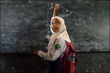 An Indonesian primary school girl sketches a map of Sumatra while explaining about the powerful earthquake that has hit the region, in Banda Aceh. Indonesia told foreign troops helping tsunami victims to get out of the country 'the sooner the better' and defended tough new restrictions on aid workers, while rich nations prepared to freeze Jakarta's debt repayments(AFP/Choo Youn-Kong) 