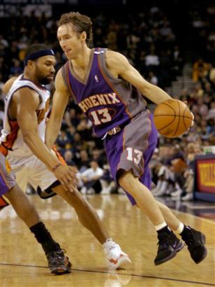 Phoenix Suns (news) guard Steve Nash (news) of Canada dribbles around Golden State Warriors (news) guard Derek Fisher (news) in the first quarter Sunday, Feb. 13, 2005, in Oakland, Calif.(AP Photo/Paul Sakuma) 