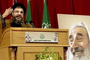 Hezbollah leader Sheik Hassan Nasrallah gestures during a rally in Beirut, Lebanon, Thursday March 31, 2005, to commemorate the first anniversary of the death of Sheik Ahmed Yassin, seen on poster at right, founder of militant group Hamas, who was killed in an Israeli airstrike in Gaza on March 22, 2004. (AP 