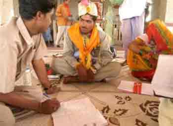 An employee of women and children welfare department, left, urges a bridegroom to refrain from living with his minor bride till she attains the age of 18, after a marriage ceremony in Rajgarh, about 105 kilometers (65 miles), northwest of Bhopal, India, Thursday, May 12, 2005. Ignoring laws that ban child marriages, hundreds of children, some as young as seven years old, were married in a centuries-old custom across central and western India this week. (AP