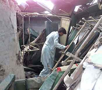 A Pakistani man surveys the wreckage of a coach after a train crash near Ghotki, 430 km (270 miles) northeast of Karachi, July 13, 2005. More than 120 people were killed and hundreds injured in Pakistan on Wednesday when a passenger train crashed into another at a station and a third train then ploughed into the wreckage, police said. [Reuters]