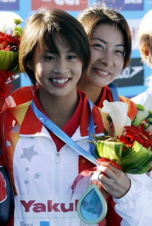 China's Li Ting [front] and Guo Jingjing hold their gold medals in the women's synchronized 3m springboard finals at the World Aquatic Championships in Montreal, July 24, 2005.