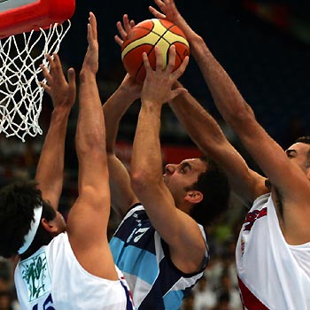 Argentina's Diego LoGrippo (C) goes for a layup while defended by Puerto Rico's Hctor Valenzuela (L) and his team mate during a Stankovic Continental Champions Cup game in Beijing July 31, 2005. Argentina beat Puerto Rico 86-79 to win the second place of the Stankovic Cup on Sunday. 