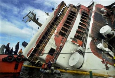 The burnt Superferry 14 lies on it's starboard side as rescuers search for missing people in Mariveles, Bataan province northwest of Manila in this Sunday Feb. 29, 2004 file photo. An 11-pound TNT firebomb crammed in a TV set that went off on a passenger ferry in Manila Bay last, killing 116 people in the Philippines' worst terror attack, employed a Jemaah Islamiyah bomb design that could be set off by an alarm clock or a cell phone.