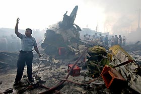 Rescue workers and residents surround the wreckage of an Indonesian Boeing 737-200 operated by Mandala Airlines which crashed just after takeoff yesterday. REUTERs