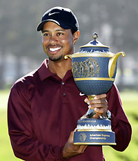 Tiger Woods holds up a trophy after winning the final round of the American Express World Golf Championships at Harding Park Golf Course in San Francisco, California, October 9, 2005.