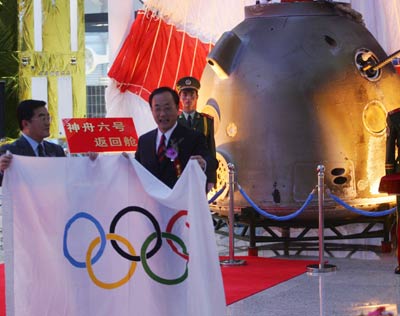 Officials display an IOC flag retrieved from the re-entry capsule of the Shenzhou VI spacecraft Wednesday October 19, 2005 in Beijing. [newsphoto]