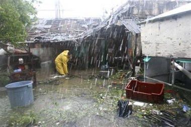 A man tries to save some of his belongings as flood waters begin to rise at a low income neighborhood during the passing of Hurricane Wilma in Playa del Carmen, Mexico on Friday Oct. 21, 2005.