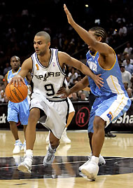 San Antonio Spurs guard Tony Parker (L) drives the lane against Denver Nuggets guard Andre Miller during the fourth quarter of their NBA game in San Antonio, Texas November 1, 2005. The Spurs defeated the Nuggets 102-91.