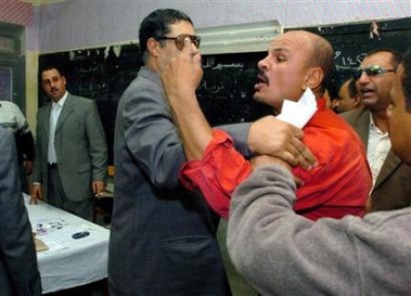 Egyptian security remove a troublemaker from a polling station during the third and final round of parliamentary election in Zagazig, north of Cairo, December 1, 2005.