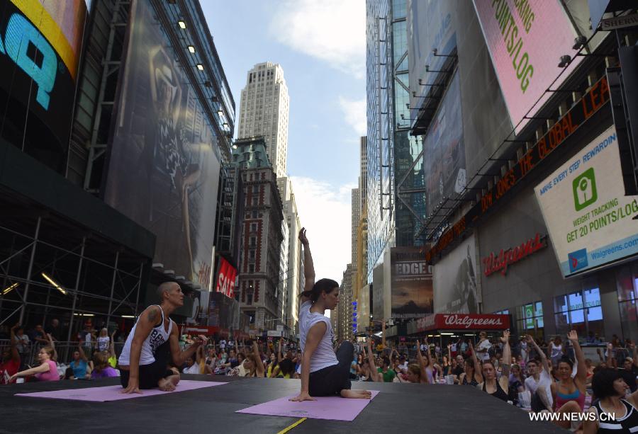 People practice yoga in Times Square to mark Summer solstice day