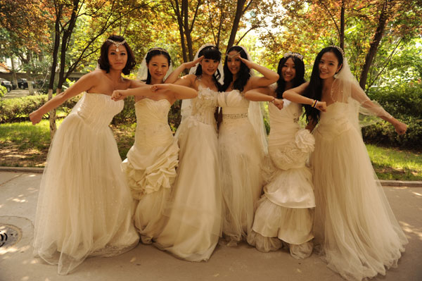 Graduates in wedding gowns honor college years