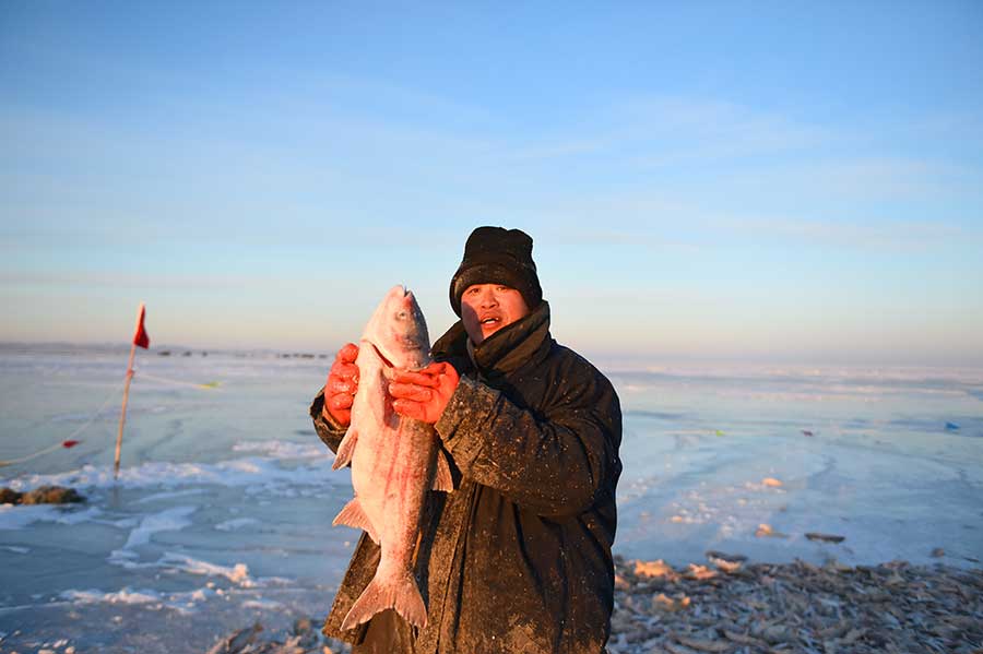 Winter fishing in ice-covered Hulun Lake in Inner Mongolia